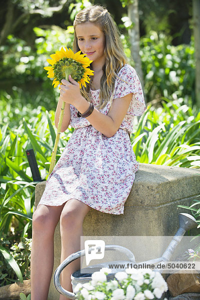 Süßes kleines Mädchen mit Sonnenblume im Freien