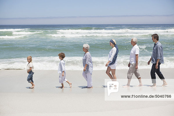 Familie am Strand mit Kindern in Reihe gehen