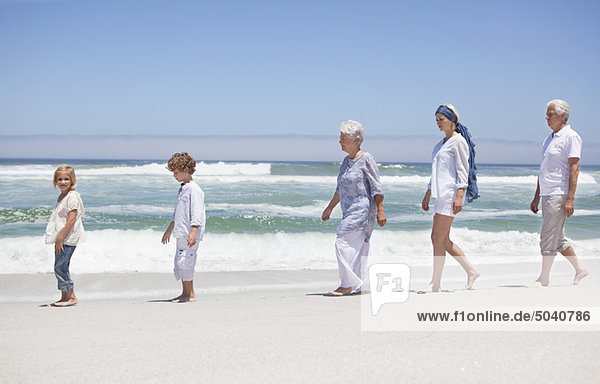 Familienspaziergang mit Kindern am Strand entlang