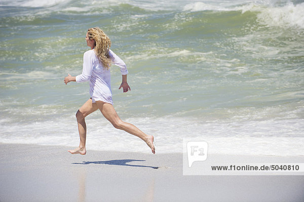 Seitenprofil einer schönen Frau  die am Strand läuft
