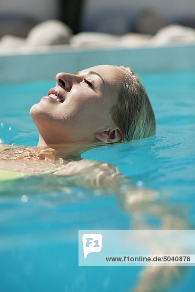 Frau entspannt sich im Schwimmbad