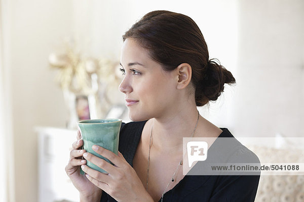 Junge Frau trinkt zu Hause Tee