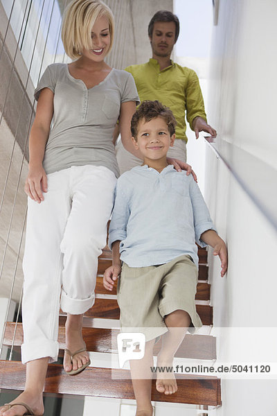 Couple with their son moving down from a staircase