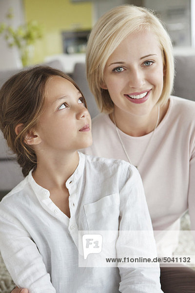 Porträt einer Frau  die mit ihrer Tochter sitzt und lächelt