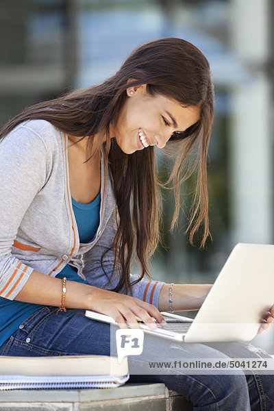 Close-up of a smiling woman using a laptop