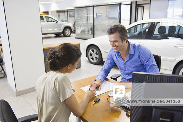 Mid adult man buying car in a showroom