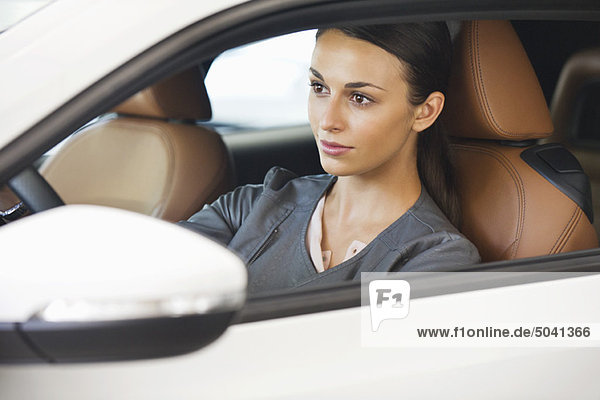 Beautiful young woman taking a test drive