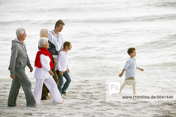 Multi-generation family walking on the beach