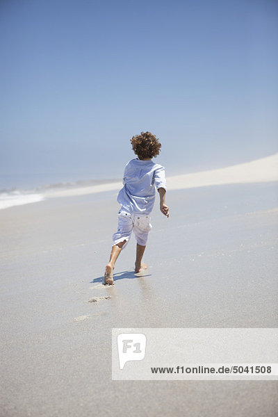 Rear view of a boy running on beach