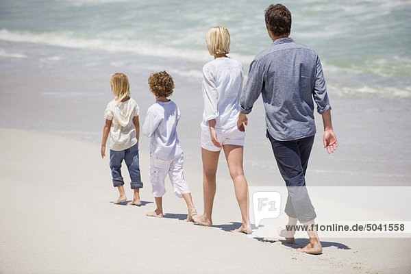 Couple with two children walking on the beach