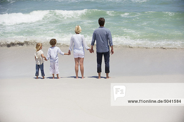 Couple with two children standing on the beach