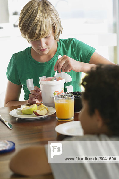Teenager-Junge beim Frühstück mit seinem Bruder  der vor ihm sitzt.