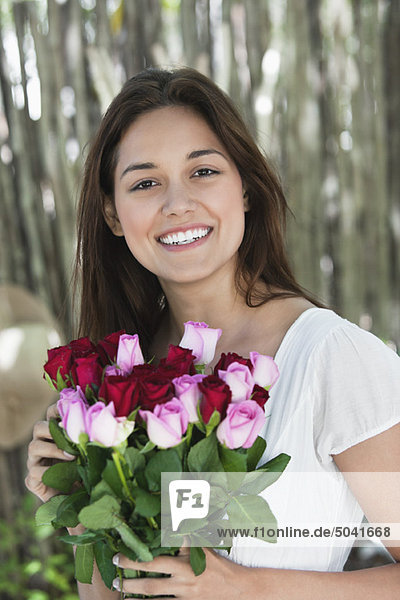 Porträt einer jungen Frau mit bunten Rosen