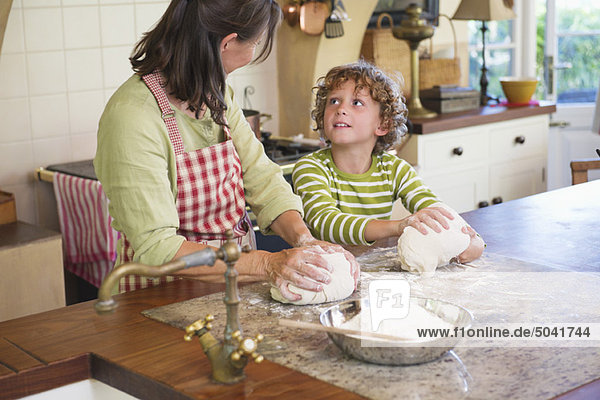 Großmutter und kleiner Junge beim Teigkneten in der Küche