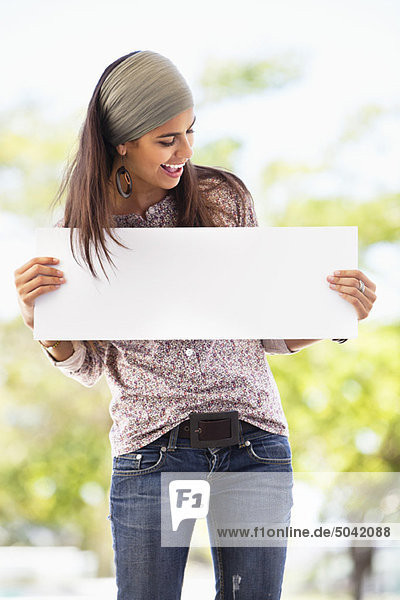 Smiling woman looking at a blank placard