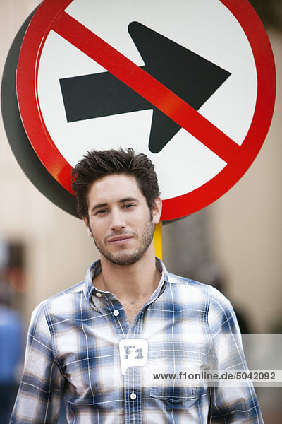 Handsome man smiling with no entry sign in the background