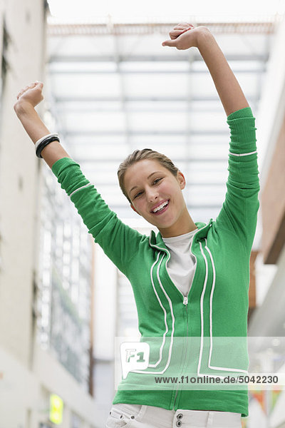 Portrait of an excited woman with arms raised