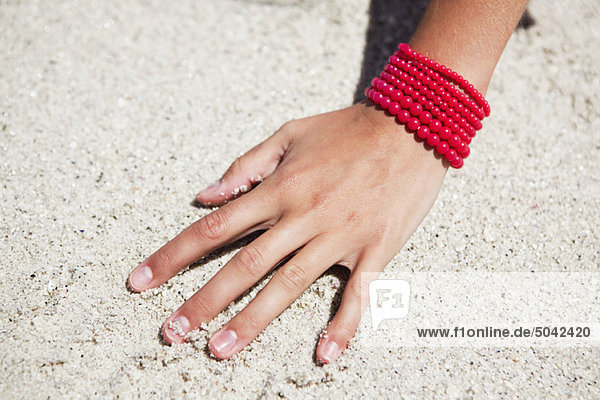 Nahaufnahme einer Frauenhand auf Sand