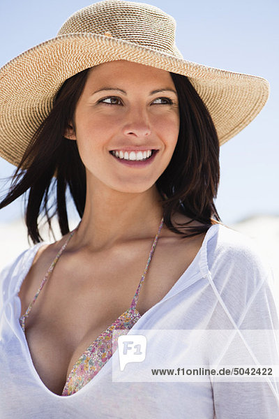 Junge Frau lächelt am Strand