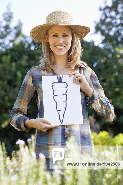 Porträt einer jungen Frau mit Karottenmalerei auf einem Feld