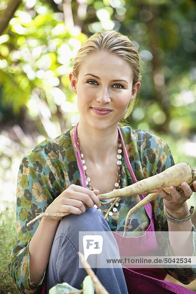 Smiling woman holding radish