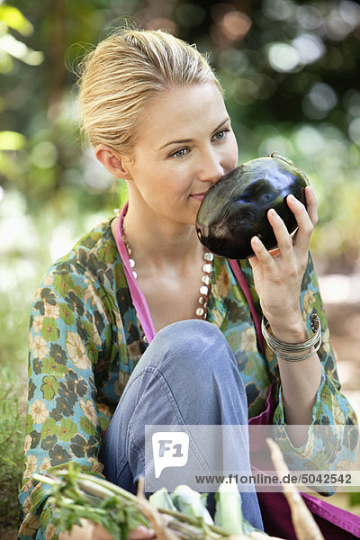 Smiling woman smelling eggplant
