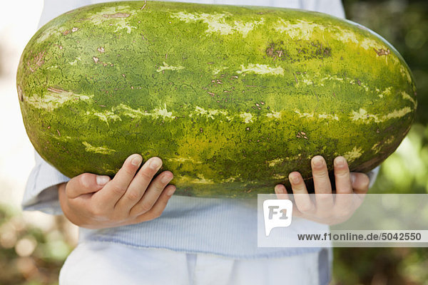 Close-up of a boy holding a watermelon