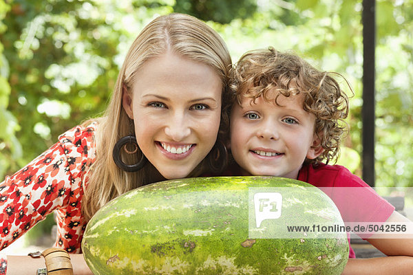Mother and son leaning on watermelon