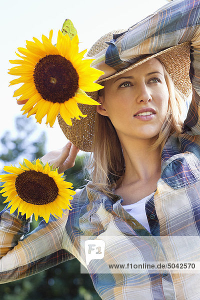 Young woman holding sunflowers