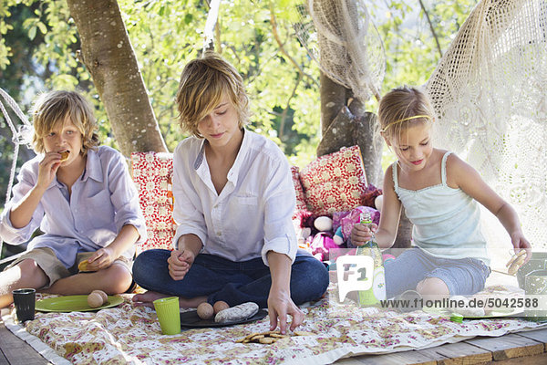 Children eating food in tree house