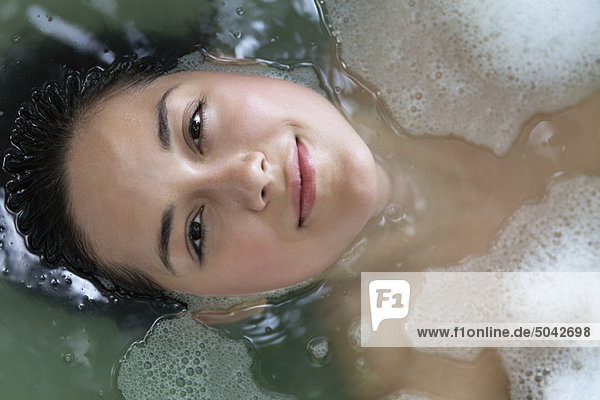 Porträt einer schönen jungen Frau  die sich in der Badewanne entspannt.