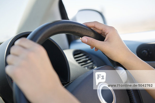 Close-up of a young woman's hand holding steering wheel