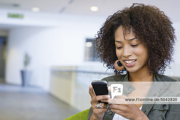 Afroamerikanerin mit Handy in der Universität