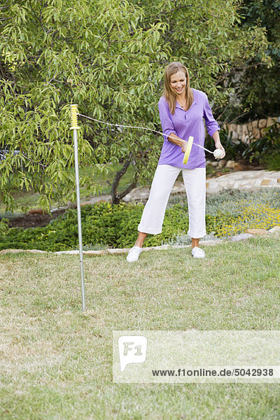 Young woman playing paddle ball in a garden