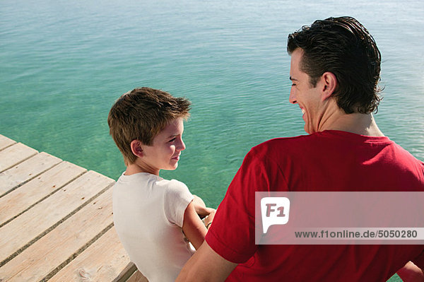 Father and son on a jetty by the sea