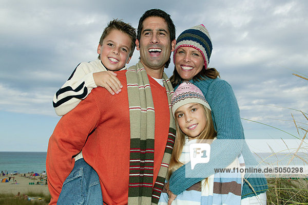 Family in warm clothes at the coast