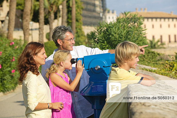 Family using telescope to look at view