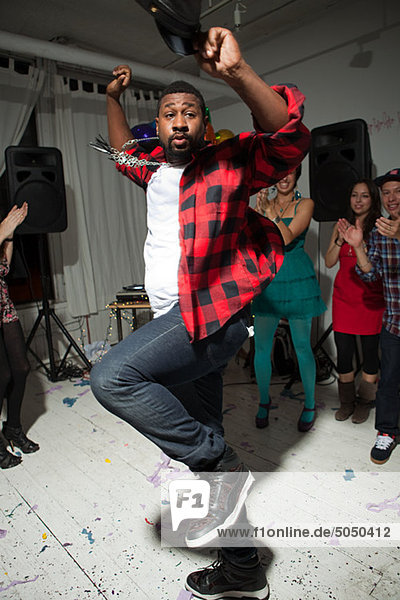 Mann mit kariertem Hemd tanzt auf der Party