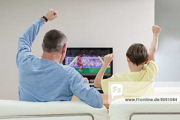 Vater und Sohn schauen Fußball im Fernsehen