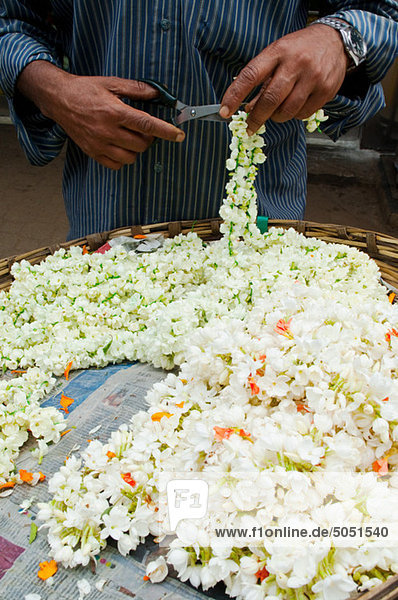 Schneiden Blumengirlanden im Markt in Mysore  Karnataka