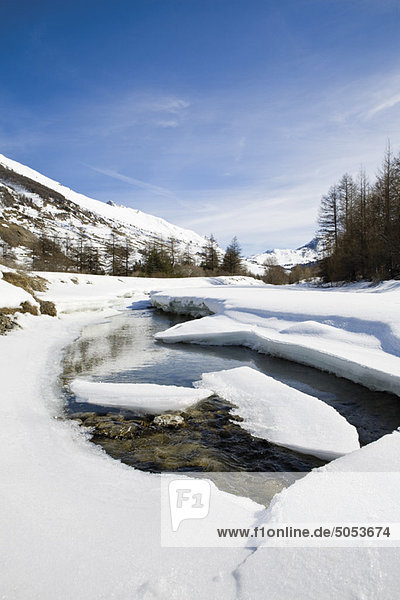 Ice floes floating on river in snowy landscape