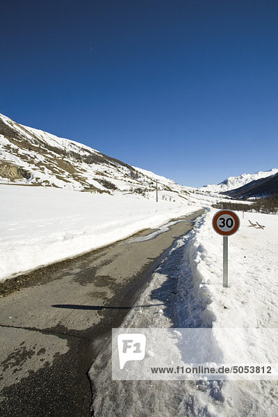 Geschwindigkeitsbegrenzungsschild auf schneebedeckter Straße