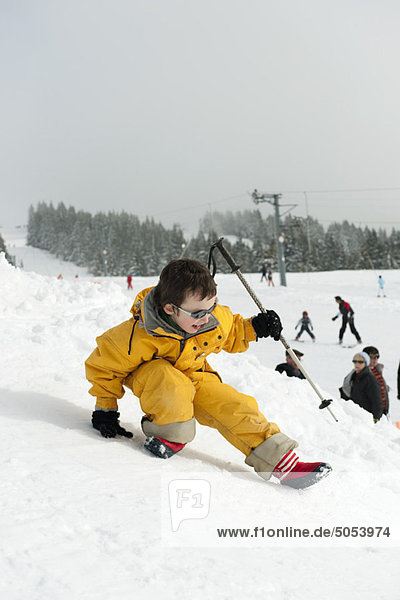 Little boy playing on ski slope