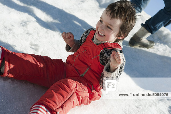Boy sitting in snow  smiling