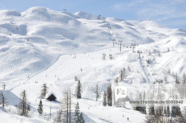 Vogel-Skigebiet in den Julischen Alpen in Slowenien  zeigt eine Sesselbahn  Skifahrer und Pisten mit Spuren im Schnee