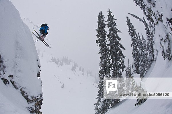 Eine männliche Freeskier lüften einer Klippe im Revelstoke Resort Backcountry  BC