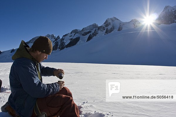 Ein Mann nimmt eine Mittagspause während Splitboarding in Fairy Wiesen Selkirk BC