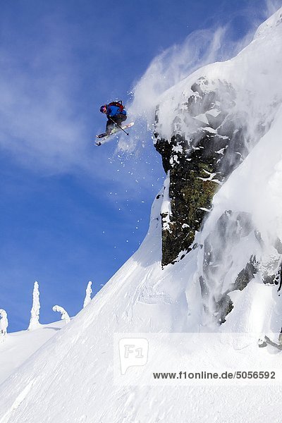 Man skiing over a rock cliff in the Whistler backcountry  Coast Mountains  British Columbia  Canada.