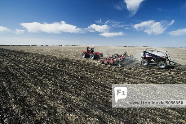 moving tractor and and air till seeder planting wheat  near Dugald  Manitoba  Canada