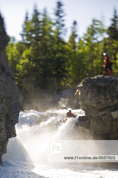 A male kayaker paddles over Elbow Falls  Elbow River  Alberta  Canada